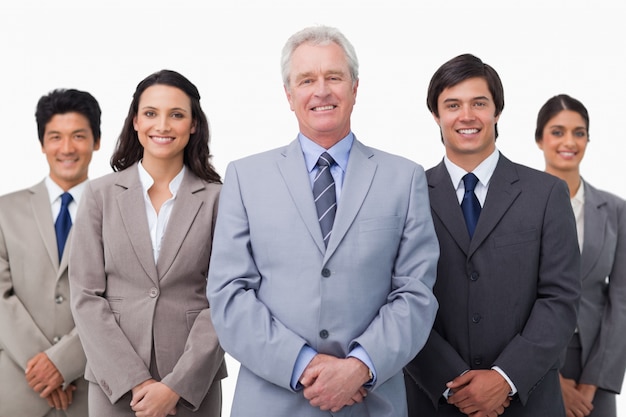 Smiling mature businessman standing with team