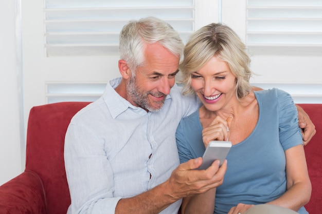 Smiling mature couple reading text message