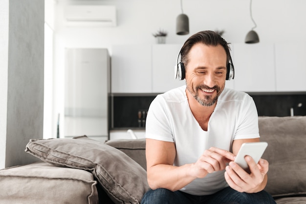 Smiling mature man listening to music with headphones