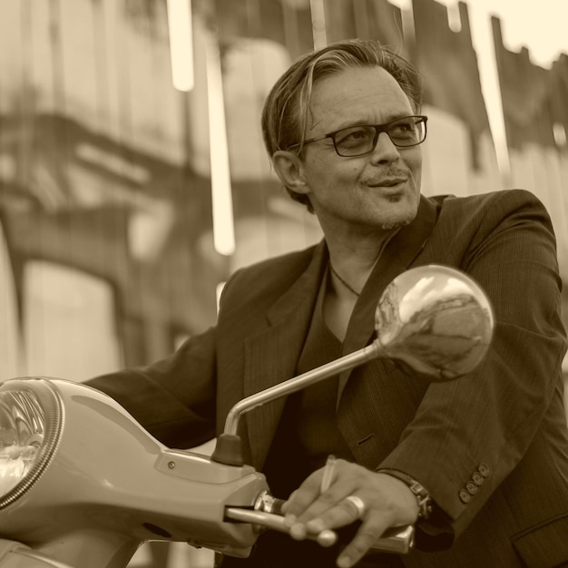 Smiling mature man looking away while driving motor scooter