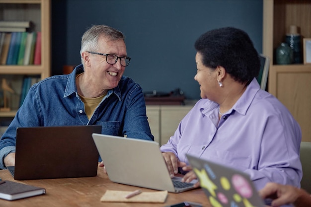 smiling mature man talking to woman using computer