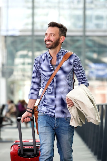 Smiling mature man traveling with suitcase