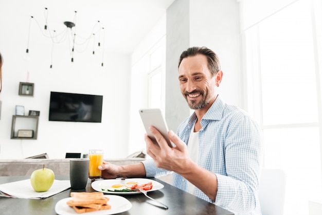 Smiling mature man using mobile phone