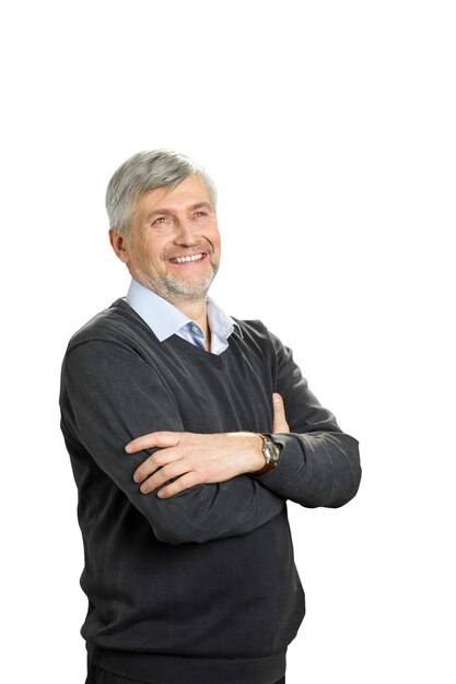 Smiling mature man with crossed arms. Portrait of cheerful senior man with crossed arms standing on white and looking upwards.