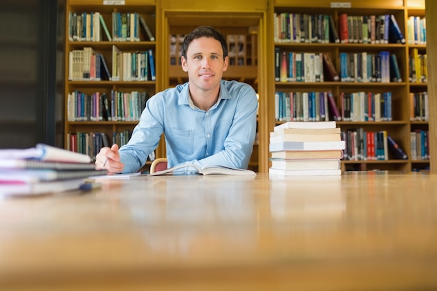 Smiling mature student studying at library desk