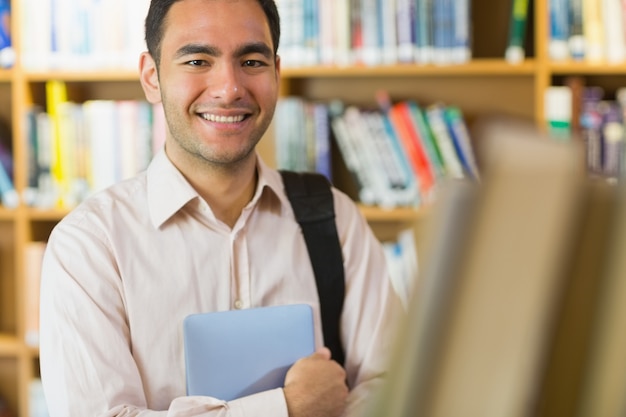 Smiling mature student with tablet PC in library