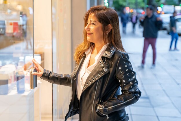 A smiling mature woman checking the storefront