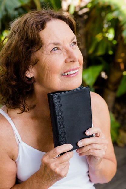 Smiling mature woman holding bible