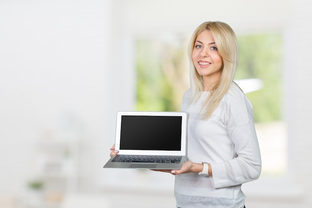 Smiling mature woman holding laptop