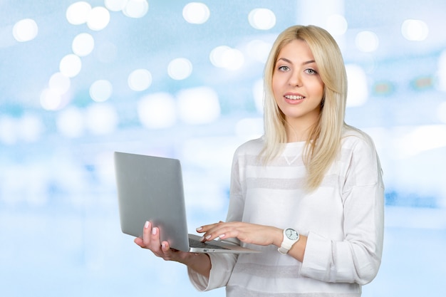 Smiling mature woman holding laptop