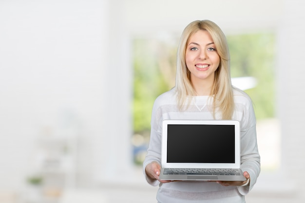 Smiling mature woman holding laptop