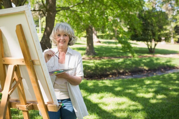 Улыбаясь зрелая женщина живопись в парке