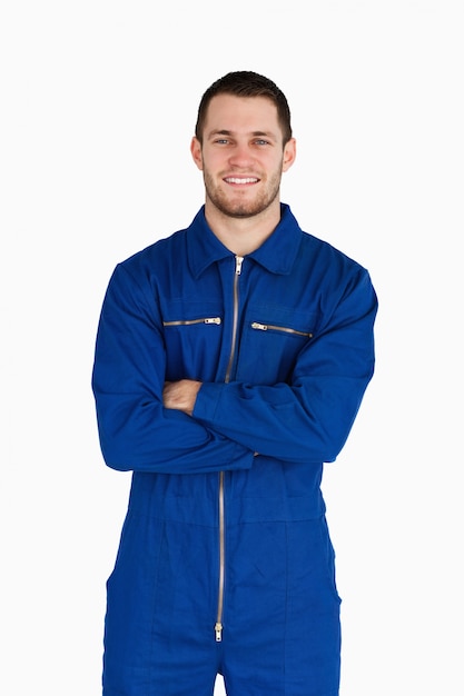 Smiling mechanic in boiler suit with folded arms