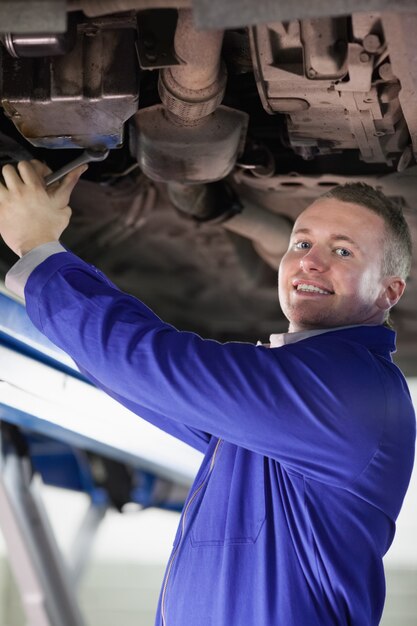 Smiling mechanic repairing a car