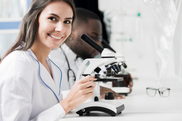 Foto medico sorridente con microscopio