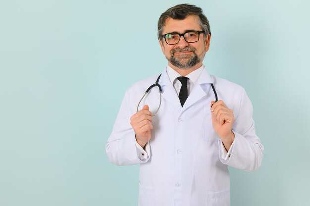 Smiling medical senior doctor with a stethoscope On a blue background The concept of humanity's victory over disease