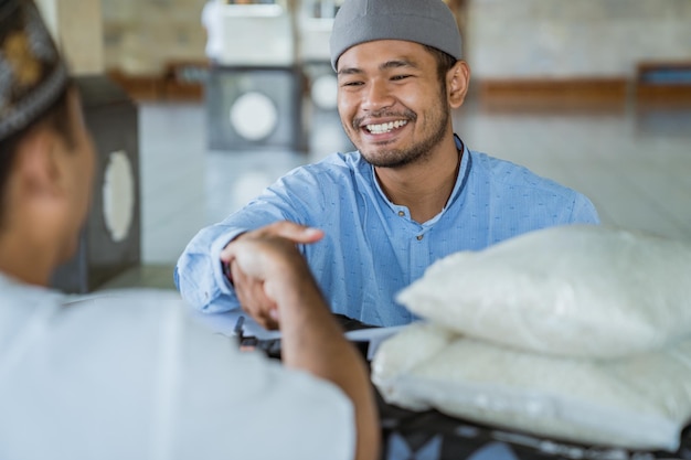 Foto uomini sorridenti che si stringono la mano in moschea