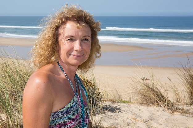 Smiling middle aged caucasian attractive woman near the ocean