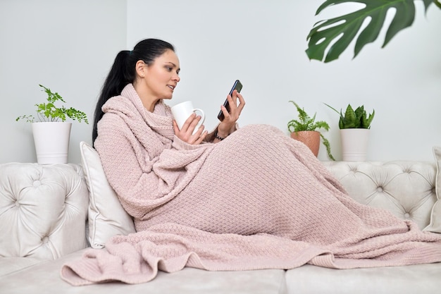 Smiling middleaged woman using smartphone for video call