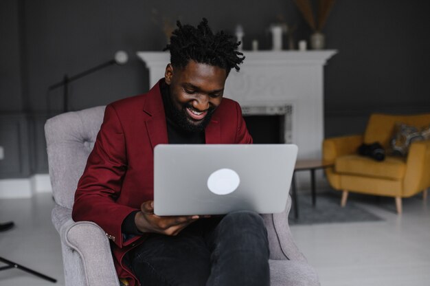 Smiling millennial african american casual man working with apps