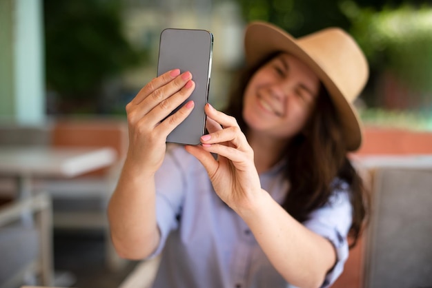 Smiling millennial woman making selfie outside