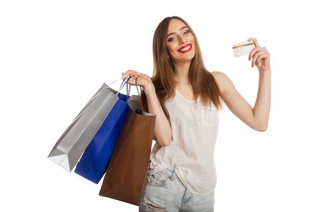 Smiling model carrying shopping bags and showing her credit card