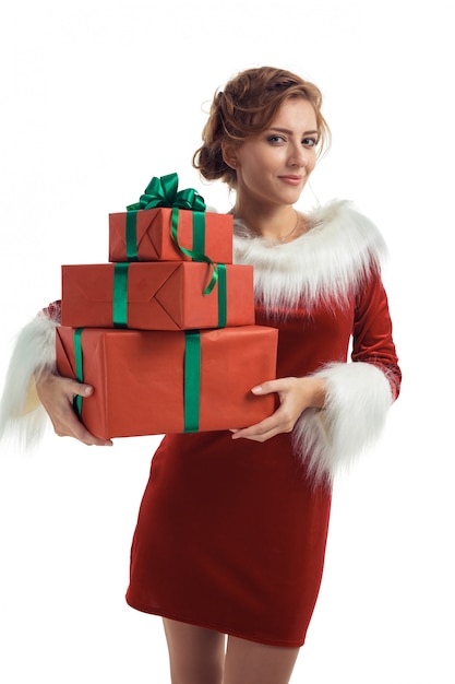 Smiling model posing in studio with gifts. Beautiful Santa Girl.