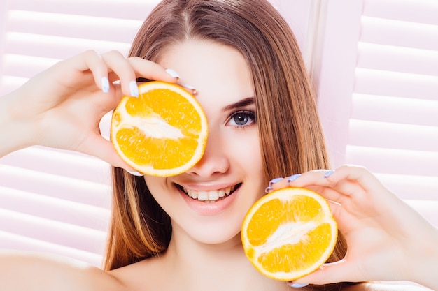 Smiling model with oranges on face