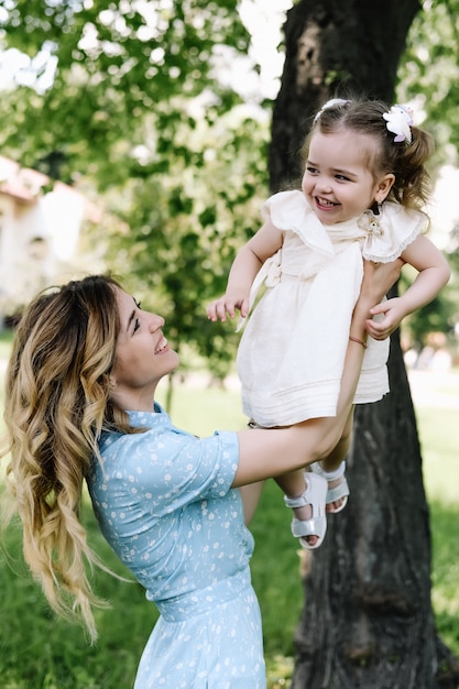 La mamma sorridente sta tenendo sua figlia