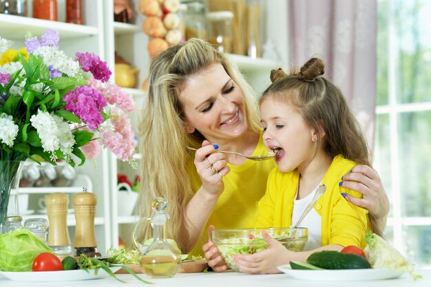 Smiling mother and daughter cooking together