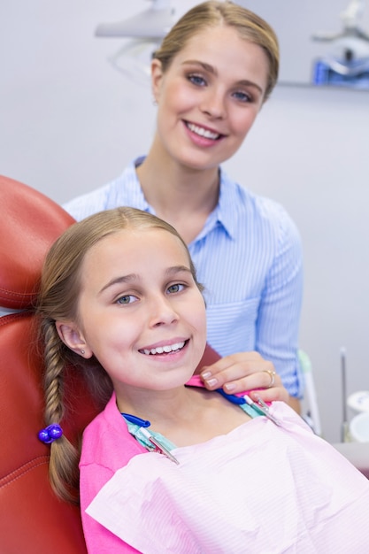 smiling mother and daughter at dental clinic