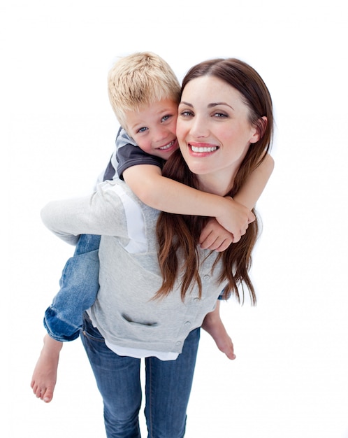 Smiling mother giving her son piggyback ride