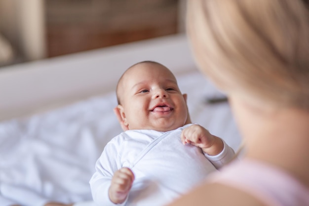 Photo smiling mother holding baby boy at home