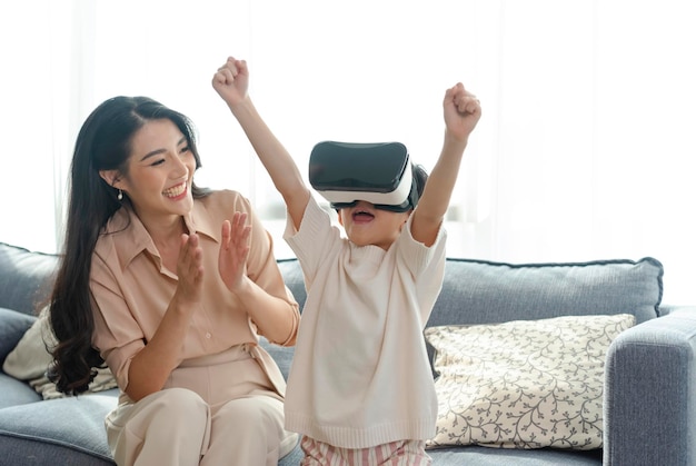 Smiling mother looking son playing games using virtual reality headsetVR at home Technology future concept