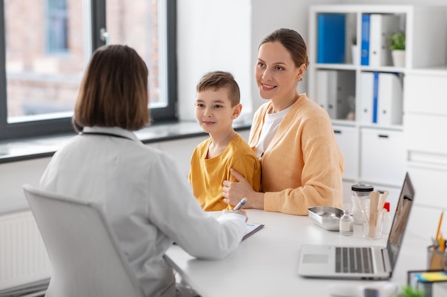 smiling mother son and doctor talking at clinic
