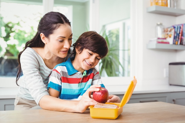 Madre e figlio sorridenti con la scatola di pranzo