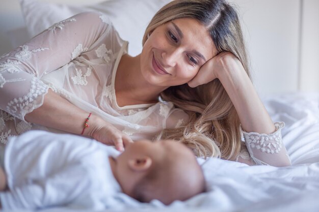 Foto madre sorridente con il bambino a letto a casa