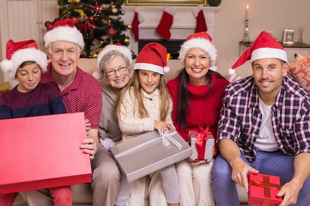 Smiling multi generation family posing with holding 