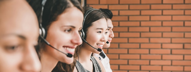 Smiling multiethnic telemarketing customer service agent team working in call center