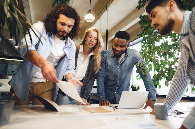 Smiling multiracial coworkers working together at office meeting have a discussion