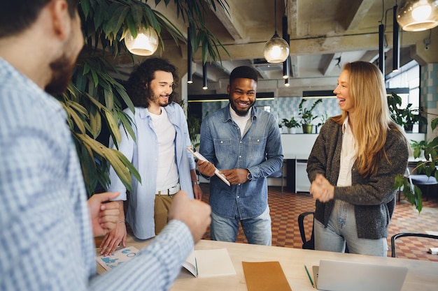 Photo smiling multiracial coworkers working together at office meeting have a discussion