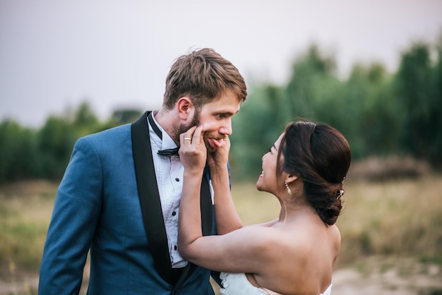 Smiling newlywed couple on field