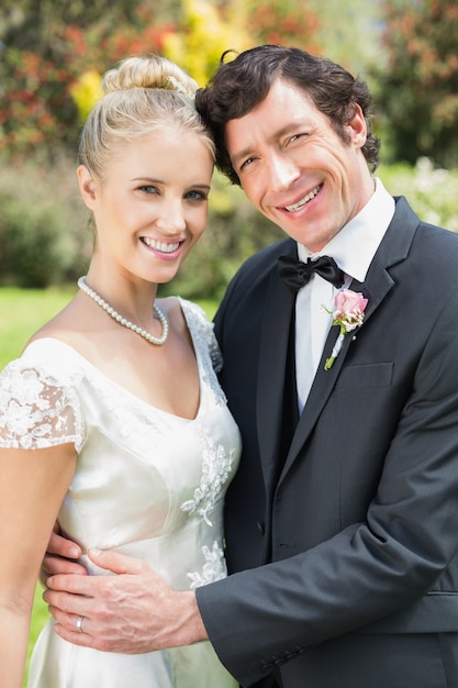 Smiling newlyweds embracing each other