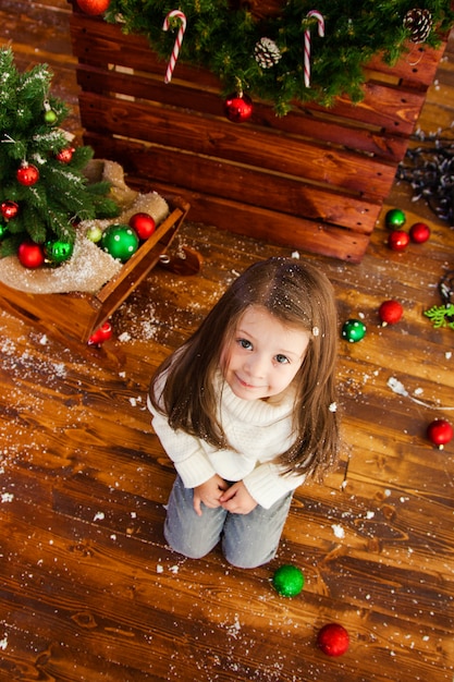 Smiling nice girl sitting on the wooden floor