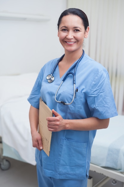 Smiling nurse holding a medical chart