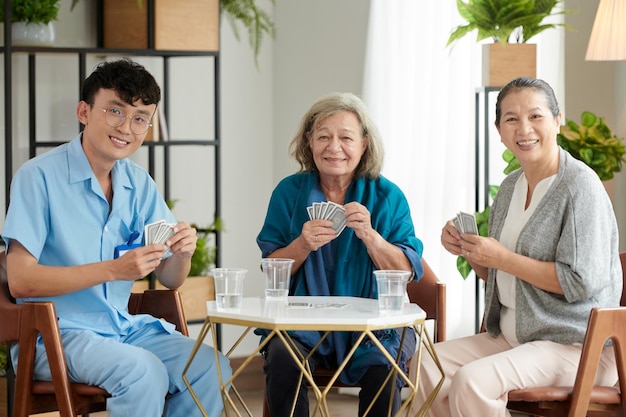 Smiling Nurse playing Cards with Patients