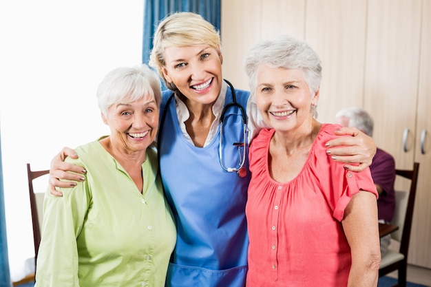立っている笑顔の看護師と年配の女性