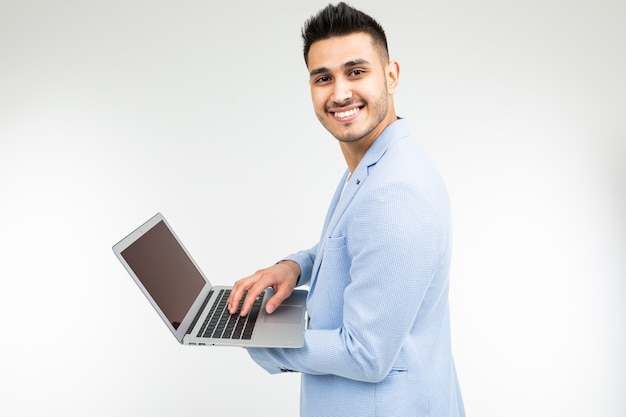 Smiling office worker man with an open laptop in his hands on a white studio