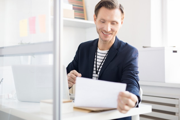 Smiling Office Worker Reading Document