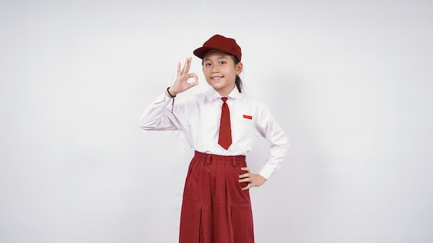 Smiling and okay asian elementary school girl isolated on white background